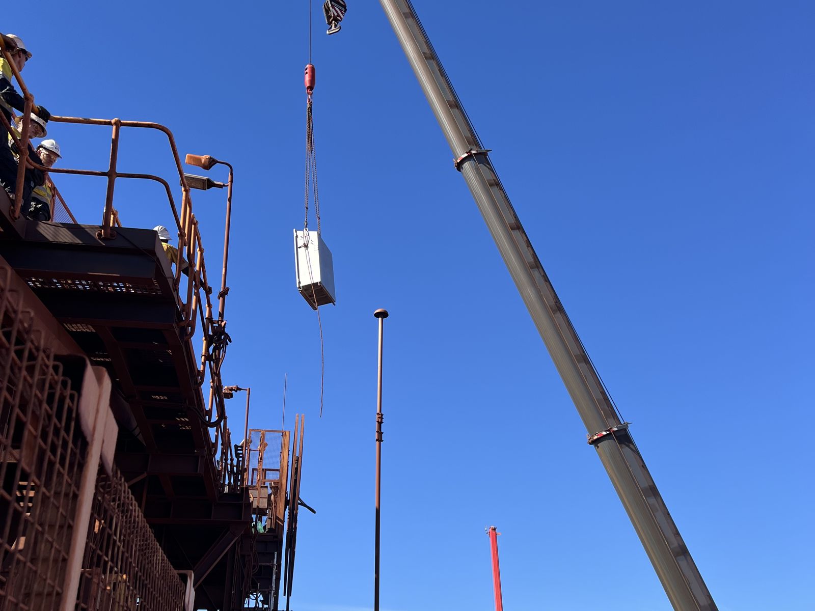 Crane lifting equipment onto a plant structure